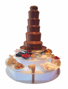 Csokoládészökőkút világító tálaló asztalon, mártogatnivalókkal